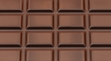 Dark Milk chocolate bar as a background. Flat lay, top view. Sweet chocolate food Pattern.