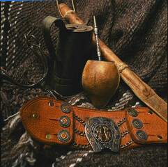 closeup of gaucho mate yerba mate elements with bombilla rebenque leather belt with chain and...