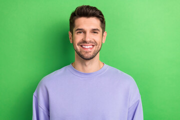 Obraz premium Photo of positive funny young guy dressed violet clothes smiling showing white teeth isolated green color background