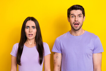 Photo of two impressed partners open mouth speechless staring isolated on yellow color background