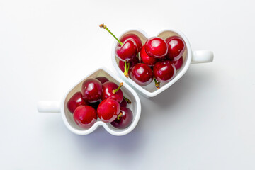 Cherries in a cup on a white background.Heart shape.Flat lay.Copy space,