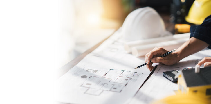 Cropped shot of Professional architect working at his desk, measuring and estimating the house project.