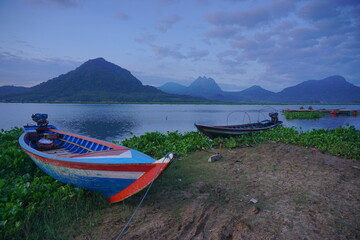 Fototapeta na wymiar Fishing boats anchored at the Jatiluhur reservoir. Beautiful view of Jatiluhur reservoir with mountains in the background.