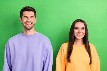 Photo of tricky cunning wife husband dressed sweatshirts smiling looking empty space isolated green...