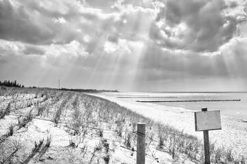 Sun rays shining through dense clouds on the beach of the Baltic Sea taken