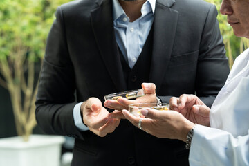 Researchers pouring hemp oil into a science glass tube, Chemist extracting cbd with rotavapor in...