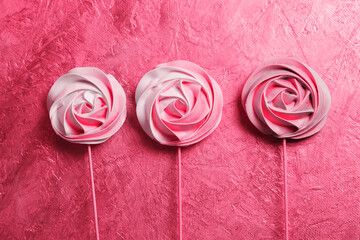 A three colorful vegetarian aquafaba meringue candy on a stick, toned in pink