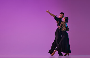 Love. Man and woman, professional dancers in stylish stage costumes performing tango over purple...