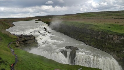 Majestic Gullfoss waterfalls attracting tourists on a cloudy day in Iceland