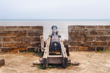 This famed tourist landmark overlooks the sea. The old lighthouse on the famous tourist spot of fort diu. Guns Guarding historical vintage fort. built by Portuguese, located in Daman and Diu, India