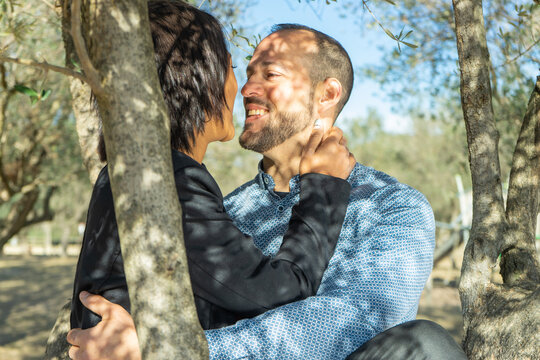 Diverse couple affectionately standing together outside on a sunny day