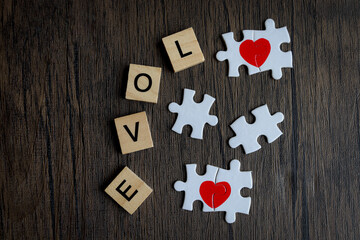 Text wooden blocks spelling the word LOVE and puzzle forming red heart  brown wooden, romantic...