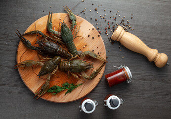 Fresh crawfish on a wooden cutting board with pepper top view