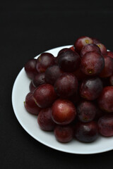 Red fresh grapes. Grapes on a plate. Large grapes.