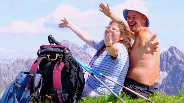 backpacks, mature tanned man and woman sitting on top mountain, Seefeld in Tirol, rests, enjoys beauty nature, trekking in mountains, extreme lifestyle, mountaineering, alpine sticks, life insurance