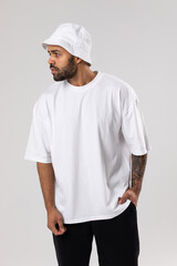 Attractive african american man with a beard dressed in a white t-shirt and panama.