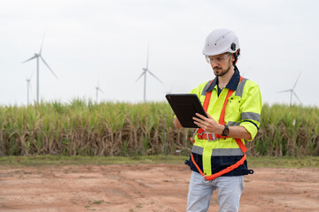 Male engineer windmill wearing uniform and helmet using tablet inspection and check wind turbine in...