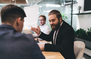 Male colleagues discussing business strategy in office