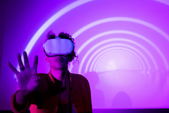 Female entrepreneur wearing futuristic glasses against projection screen in exhibition center