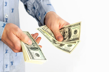 Businessman in blue shirt counts bills for 100 dollars