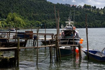 antique wooden jetty with boats in the navia river