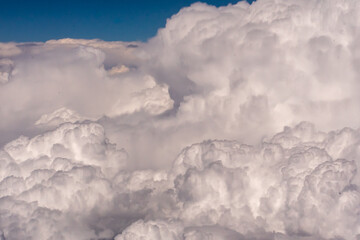 Aerial view of large puffy clouds outside of my airplane window