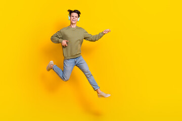 Fototapeta na wymiar Full length portrait of carefree active person jumping hands play imagine guitar empty space isolated on yellow color background