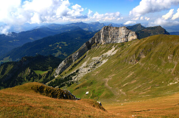 Landscape with a mountain in the foreground and long mountain ranges in the background against a blue sky with clouds on Mount Pilatus, near Lucerne, Switzerland