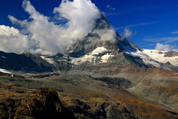 A landscape with a mountain Matterhorn view partially covered by clouds on a mountain Gornergrat,...