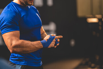 Closeup of hands of young male athlete trainer determined to workout for a healthy lifestyle tying...