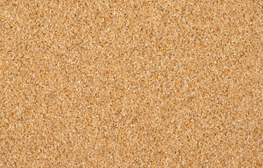 Brown sand in a random arrangement of grains.

