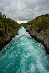 Wasserfall frontal von oben mit türkisem Wasser und grünen Bäumen. Die Huka Falls in Neuseeland.