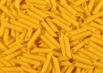 Raw pene pasta in a random arrangement.