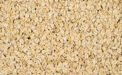 Dry oat flakes scattered randomly. Top view.