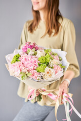 Florist woman creates beautiful bouquet of mixed flowers with hydrangea, lilac and peony roses by David Austin. European floral shop concept. Handsome fresh bunch. Education, master class and