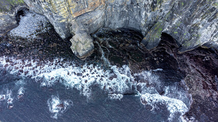 vista aerea de un mar enfurecido con grandes olas rompiendo en las rocas de un acantilado