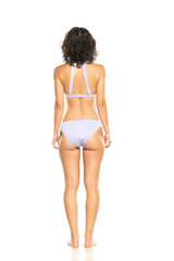 Young brunette woman in lilac bikini swimsuit posing on a white background. Back, rear view.
