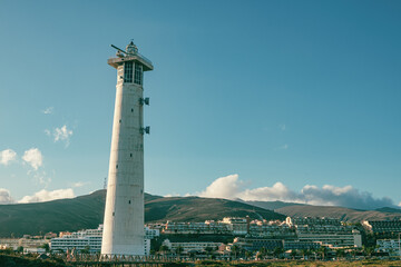 Fototapeta na wymiar Morro Jable lighthouse, built of concrete in 1991 in the marshes of the Jandía peninsula of Fuerteventura, in the Canary Islands, Spain