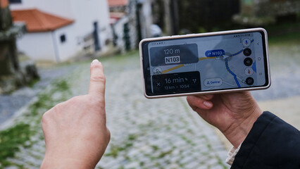 Mujer indicando con el dedo la dirección que le marca el gps del móvil © Rebeca Vidal