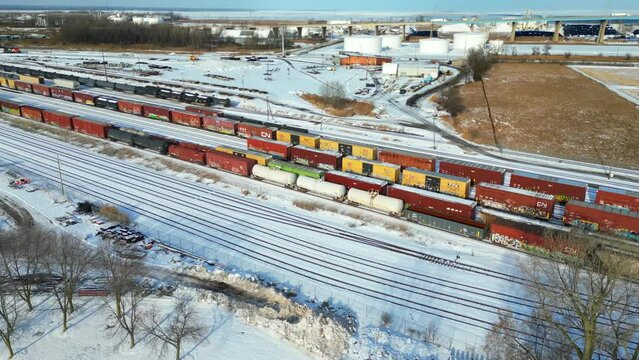 Trains in rail yard in winter, aerial view. It is fascinating to see the imprints where other train cars were parked when it snowed, now showing the voids, shadows of cars that are no longer there.