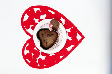 Chocolate heart-shaped muffin with heart and love on red hearts on flat lay picture
