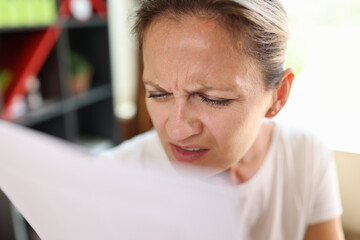 Woman with incredulous face reading documents close up.