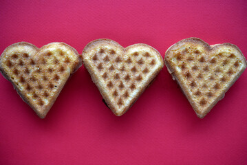 Waffle hearts on a red background. Valentine's day. Confectionery products in the form of a heart.