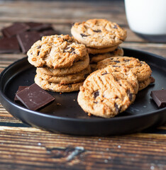 Chocolate cookies with pieces of chocolate on a wooden background