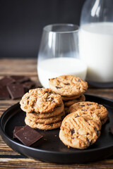 Chocolate cookies with pieces of chocolate on a wooden background