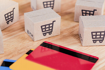 Shopping online. Credit card and cardboard box with a shopping cart logo on wood table. Shopping service on The online web. offers home delivery.