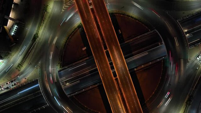Hyperlapse time-lapse of car traffic transportation above circle roundabout road in Asian city. Drone aerial view 4K drone aerial zoom out of circle, high angle.
