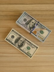 two stacks of 100 dollar bills lie on the table