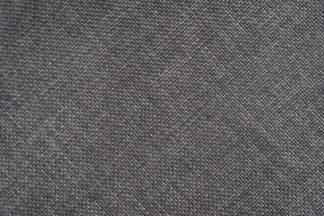 Fototapeta na wymiar Jacquard woven upholstery, gray coarse fabric texture with diagonal weave lines. Textile background, furniture textile material, wallpaper, backdrop. Cloth structure close up.