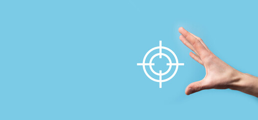 Targeting concept with hand holding target icon dartboard sketch on chalkboard. Objective target...